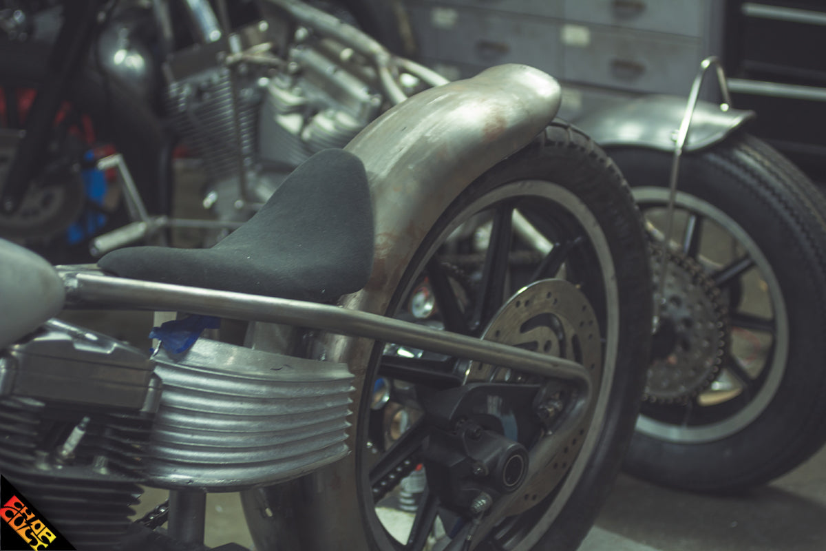 Custom sportster motorcycle rear tire in shop