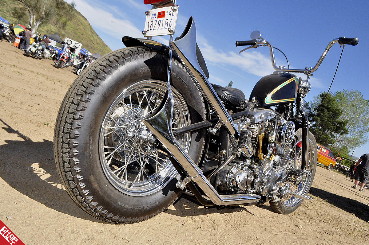 Custom shovelhead motorcycle rear angle showing exhaust pipes