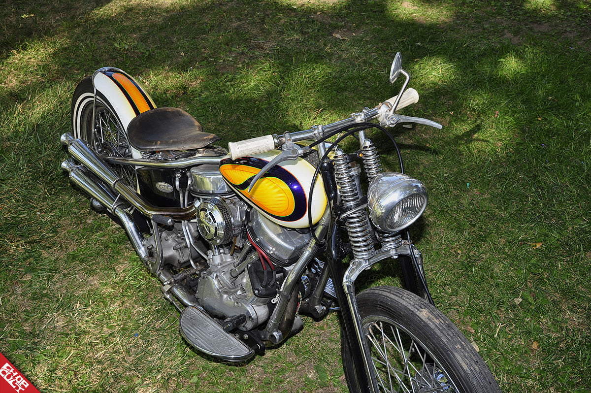 An arial view of the bike displaying its paint job, exhaust pipes, handle bars, tires, and foot pegs