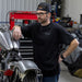 Man leaning on motorcycle wearing black shirt
