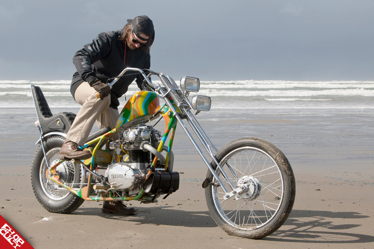 A photo of Chad riding his colorful bike on the beach