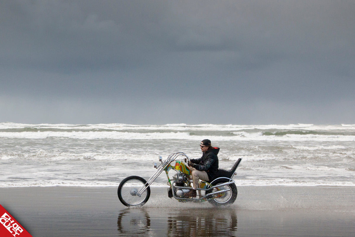 A photo of Chad riding his bike down the beach featuring the left side of the bike